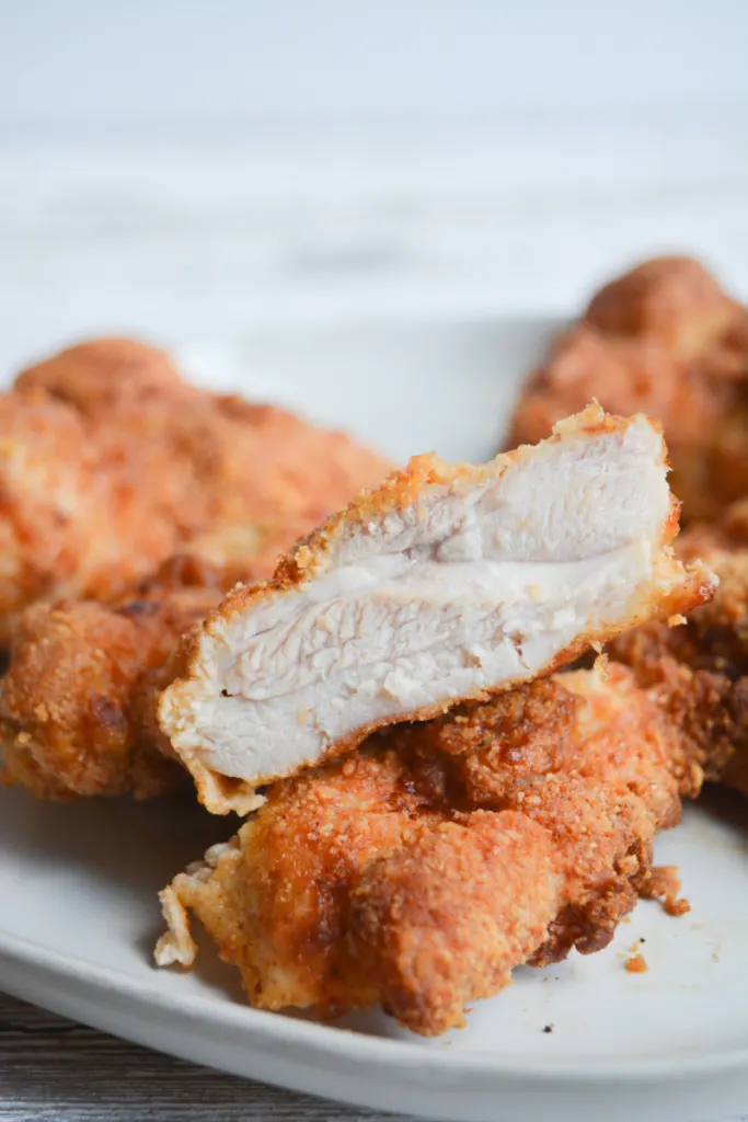 crispy low carb air fryer keto fried chicken, cut open to show juicy and delicious inside